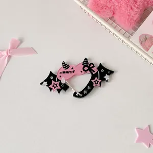 Close-up of pink acrylic heart carabiner with black bat wings and star pattern details