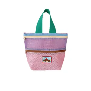 Contrast color mesh beach bag with green handles and a double zipper storage compartment