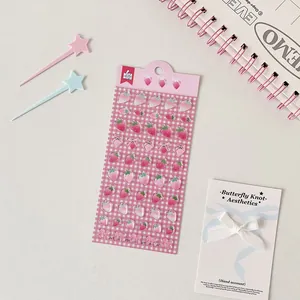 Detailed view of 3D resin strawberry and bow stickers for DIY planner decoration