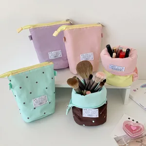 Vertical polka dot canvas pouch showing standing storage for brushes and makeup