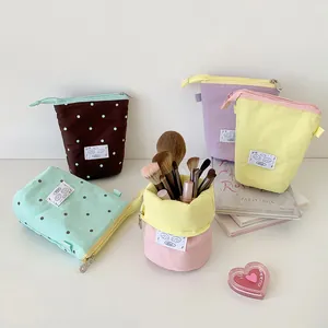 Foldable canvas pencil case standing as a desk organizer in multiple pastel colors