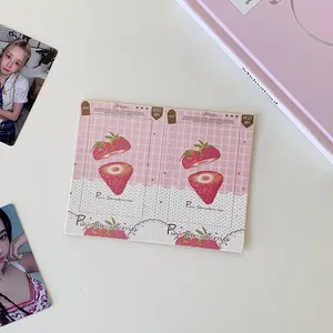 Pink checkered strawberry keychain holder displayed with aesthetic photo cards