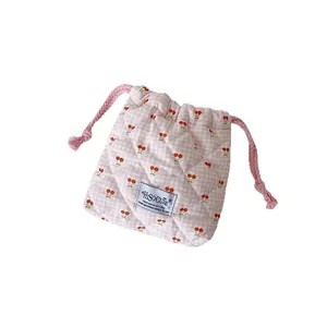 Pink checkered quilted drawstring bag with cherry print and decorative cloth label