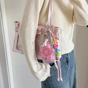 Pink ruffled tote bag featuring a cute stuffed flower and Lucky bead keychain charms