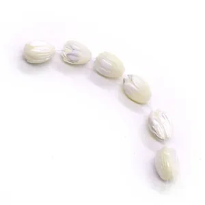 Macro detail of tulip-shaped cream pearl beads for DIY jewelry with satin texture