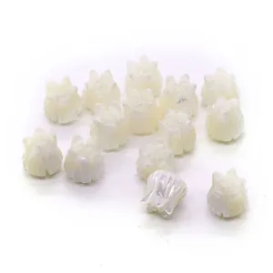 Macro detail of white tulip carved mother of pearl shell beads with iridescent luster