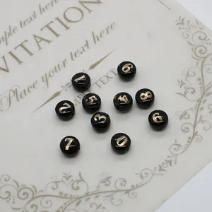 Détail de perles rondes en résine noire avec chiffres dorés pour bijoux DIY