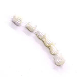 Detailed view of white tulip-shaped pearl beads with iridescent luster for DIY jewelry