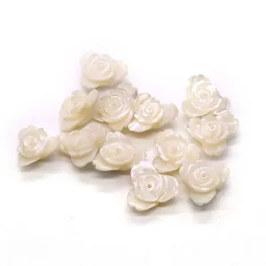 Macro shot of white carved shell rose beads with drill holes for DIY jewelry making