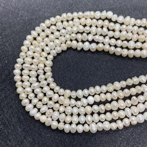 Détail macro de fils de perles d'eau douce baroques blanc naturel au lustre irisé