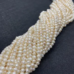 Gros plan de perles d'eau douce blanc crème à haute brillance sur un fond noir texturé