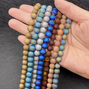 Close-up of colorful plated matte agate round beads held in hand for DIY jewelry making