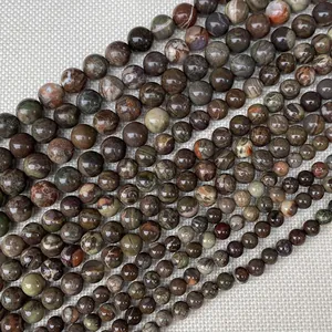 Vue macro de perles rondes en pierre naturelle avec textures minérales vertes et rouges