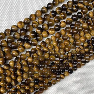 Vue détaillée de perles rondes en œil de tigre naturel avec un éclat soyeux poli