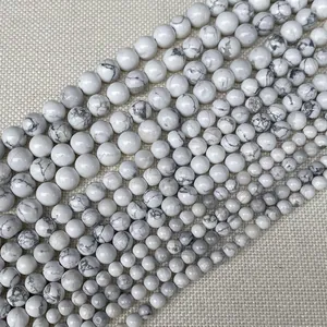 Gros plan de perles rondes en howlite blanche avec texture marbrée grise naturelle et éclat