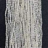 Κοντινό πλάνο με λευκές πέρλες ρυζιού για DIY κοσμήματα σε μαύρο φόντο με υφή