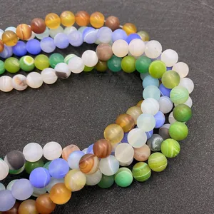 Gros plan de perles en pierre naturelle mate aux textures rayées pour bijoux DIY