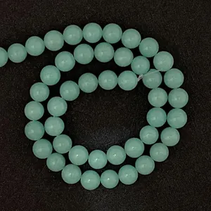 Dettaglio ravvicinato di perle tonde in pietra naturale verde chiaro per gioielli fai da te