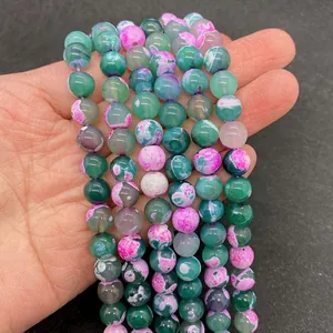 Macro detail of 8mm green and magenta dragon vein agate beads for DIY jewelry