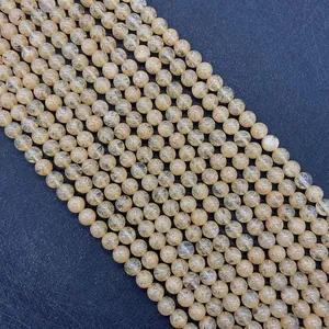 Macro shot of yellow rutilated quartz beads showing natural mineral hair-like inclusions