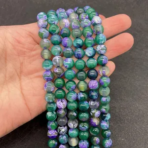 Macro detail of natural dragon vein agate round beads in vibrant green and purple tones