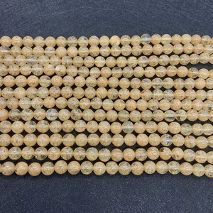 Macro detail of yellow rutilated quartz beads showing golden needle inclusions for DIY