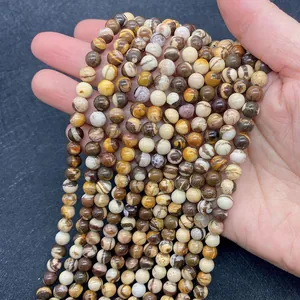 Détail macro de perles rondes en jaspe zèbre australien naturel tenues à la main pour DIY