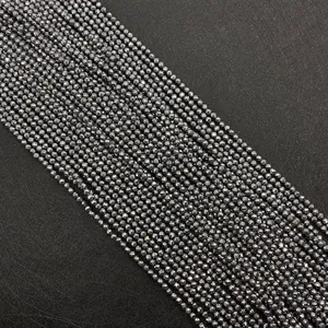 Vue macro de perles d'hématite gris foncé facettées de 2-4 mm avec éclat métallique DIY