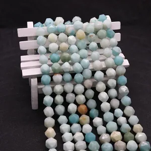 Macro shot of faceted natural Amazonite stone beads displayed on a white miniature bench