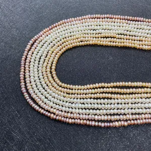 Detailed macro view of 3-5mm natural freshwater pearls in multi-color strands on black