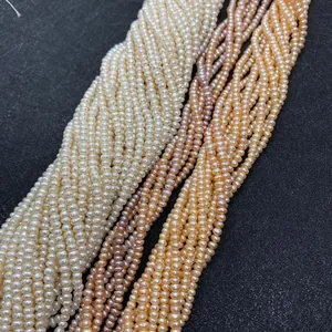 Detail of natural freshwater seed pearls in white, pink, and orange on a dark tray