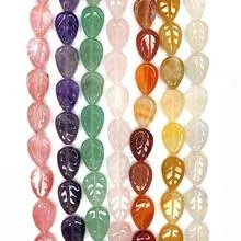 Detailed close-up of leaf-shaped natural stone beads with intricate carved vein textures