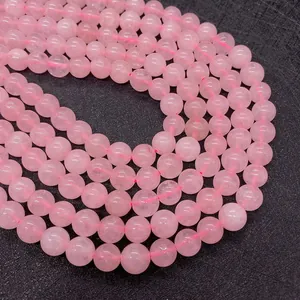 Macro shot of polished round pink natural crystal beads showing internal ice textures