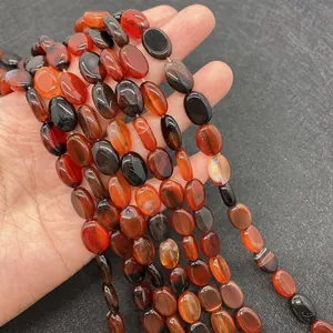 Nahaufnahme ovaler roter Achatperlen mit natürlicher Maserung für DIY-Schmuck