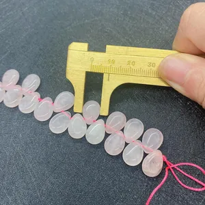 Detail shot showing measurement of a pink quartz drop bead with golden calipers