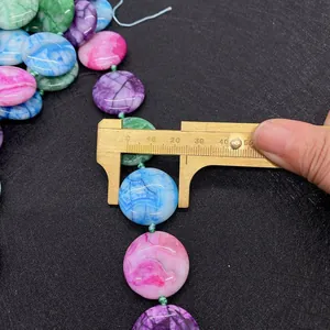 Detailansicht der Messung einer 18mm flachen runden Achatperle mit einem Messschieber