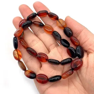 Natürliche rote Achat-Perlen oval 10x14mm für DIY-Schmuck auf einer Hand präsentiert