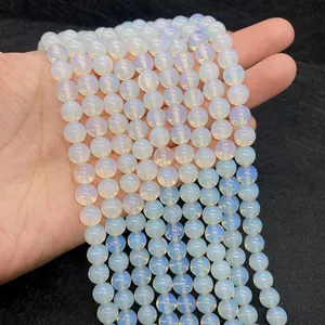 Dettaglio macro di perline di opale bianco traslucido con lucentezza blu su fondo nero
