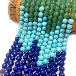 Polished natural aventurine, turquoise and lapis lazuli round beads on bamboo mat
