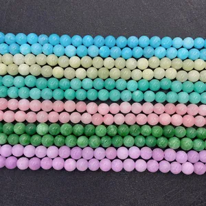 Polished natural stones in pastel colors like pink and blue arranged in rows for DIY jewelry