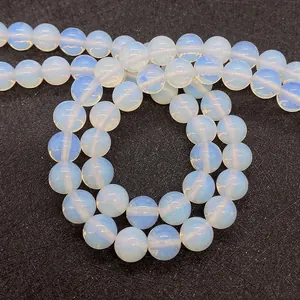Dettaglio di perle di opale bianco traslucido da 8mm con riflessi blu per gioielli fai-da-te