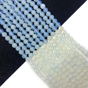 Perle rotonde di opalite lucida con riflessi blu su sfondo bianco e nero