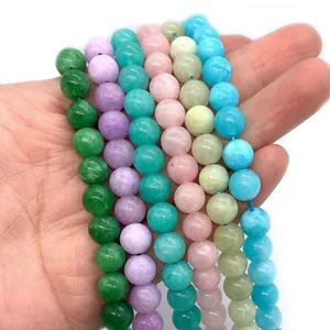 Handheld view of multi-colored natural morganite gemstone beads for DIY jewelry making
