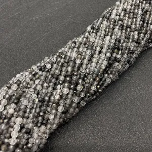 Dettaglio di perline sfaccettate in quarzo rutilato nero naturale per gioielli
