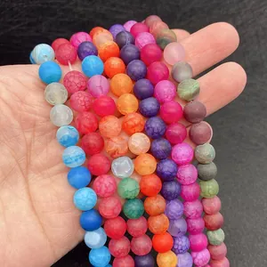 Colorful matte dragon vein agate beads held in hand for DIY jewelry making and bracelets