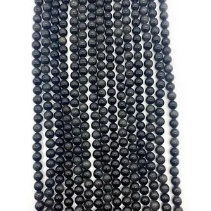 Dettaglio di perle tonde in ossidiana nera lucida per gioielli e braccialetti fai-da-te