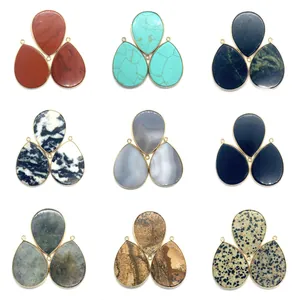 Détail de pendentifs en pierre naturelle en forme de goutte avec bordure en métal doré