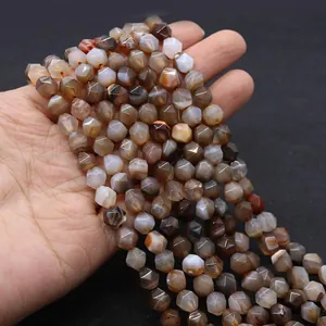 Close-up of hand holding faceted striped Botswana agate beads for DIY jewelry making