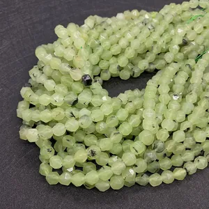 Macro shot of faceted light green prehnite stone beads with natural black inclusions