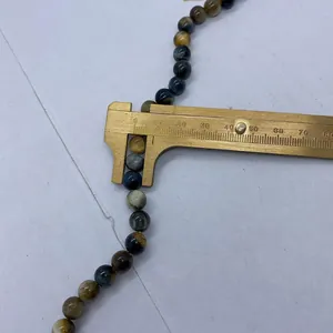 Macro shot of a vernier caliper measuring an 8mm natural tiger eye stone bead